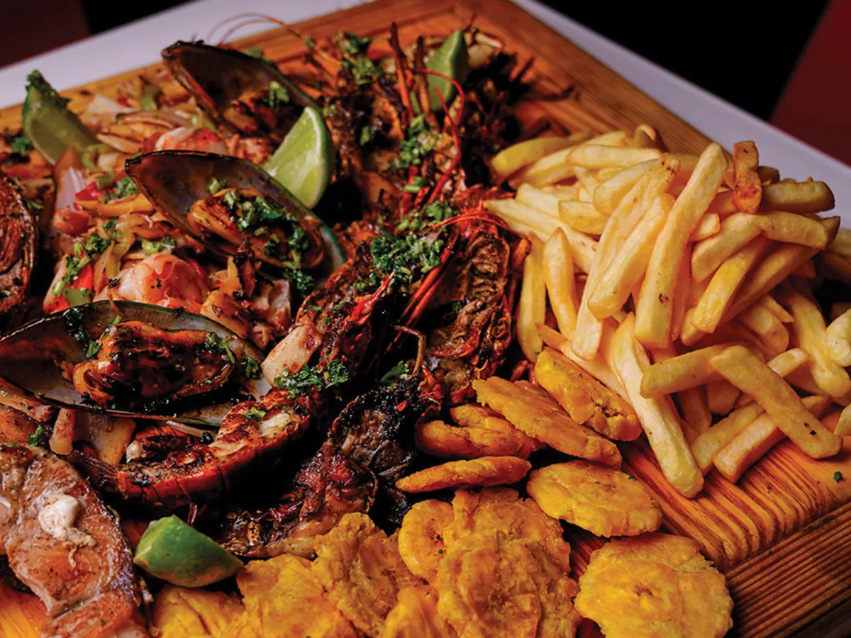 Parrillada con mariscos, carnes, papas fritas y tostones